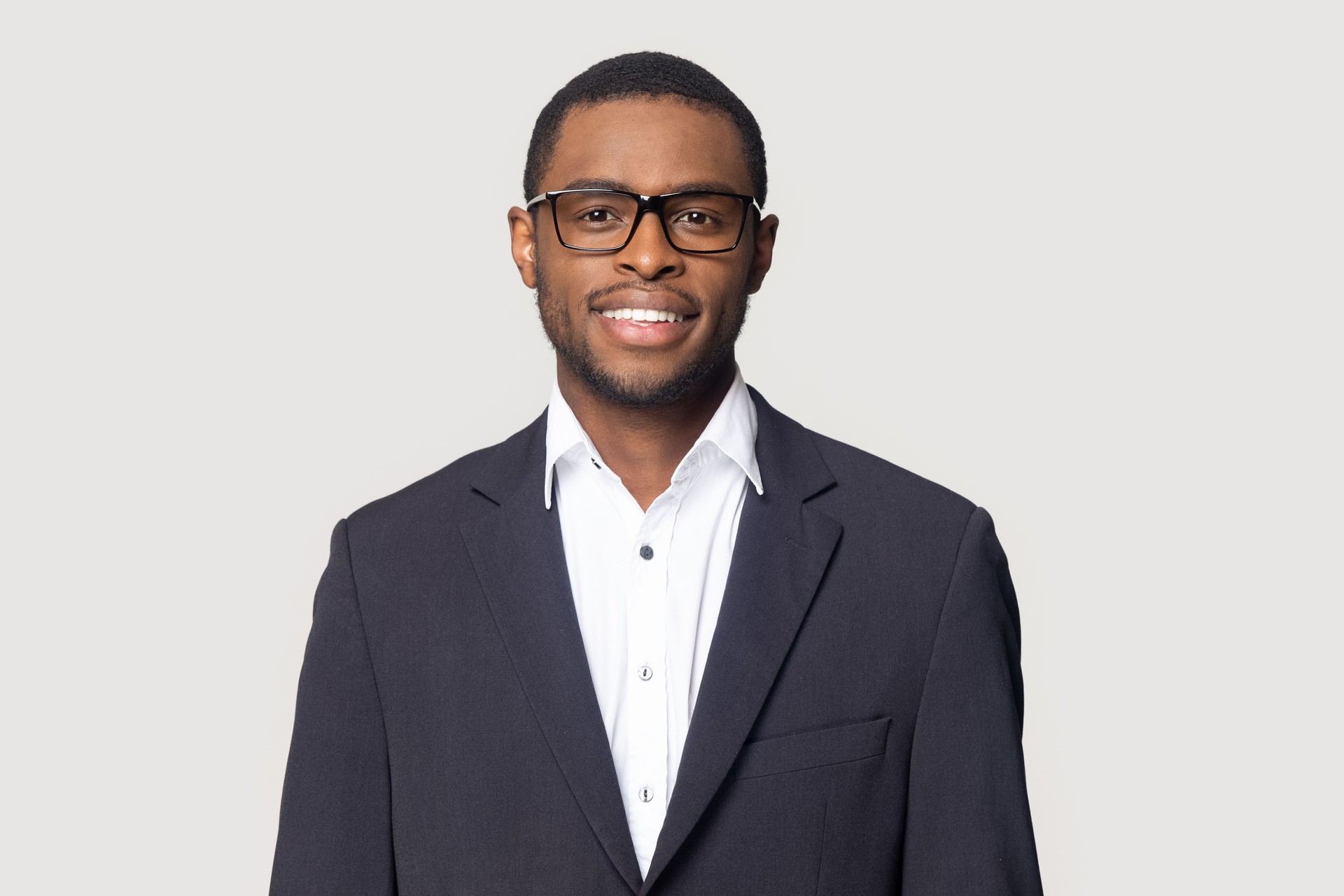 Smiling black man in suit posing on studio background